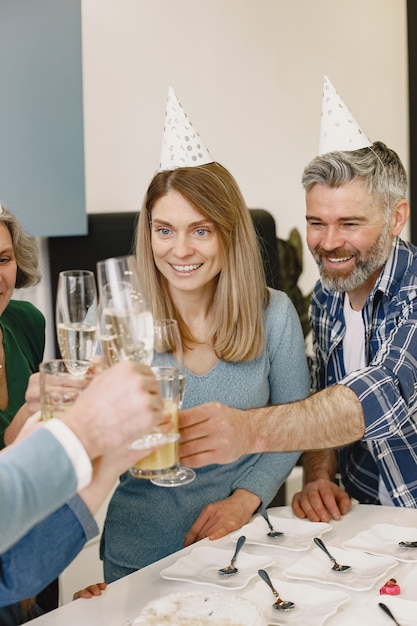 Familie en hun twee dochters vieren de verjaardag van oma's Mensen rammelen hun glas met champagne