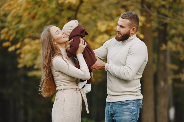 Gratis foto familie in een herfstpark. man in een bruine trui. leuk meisje met ouders.