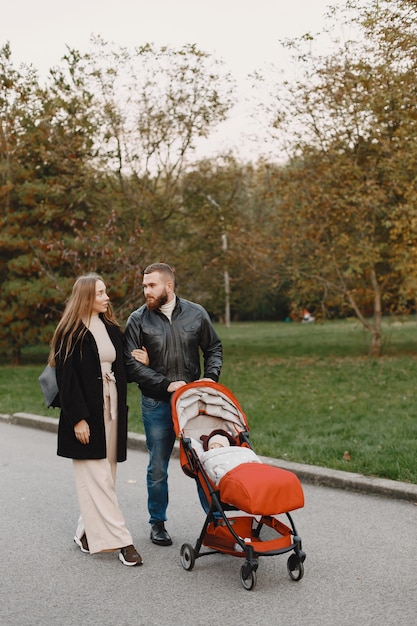 Gratis foto familie in een herfstpark. man in een zwart jasje. leuk meisje met ouders.