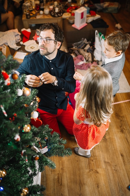 Familie in woonkamer met kerstboom