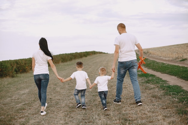 Familie loopt in een veld en speelt met een speelgoedvliegtuig