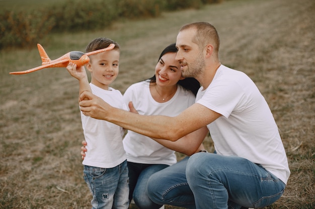 Familie loopt in een veld en speelt met speelgoedvliegtuig