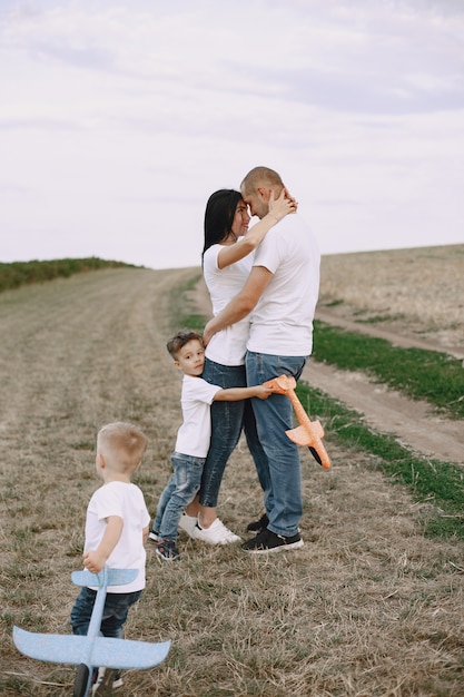 Familie loopt in een veld en speelt met speelgoedvliegtuig