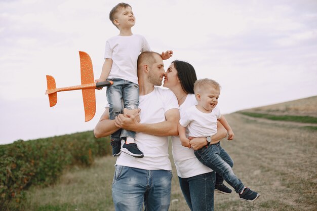 Familie loopt in een veld en speelt met speelgoedvliegtuig