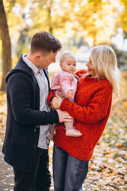 Familie met baby dochter die in een de herfstpark loopt