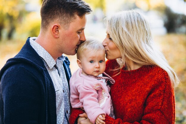 Familie met baby dochter die in een de herfstpark loopt