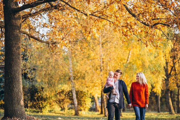 Familie met babydochter die in een de herfstpark loopt