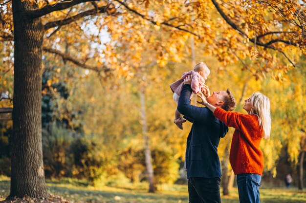 Familie met babydochter die in een de herfstpark loopt