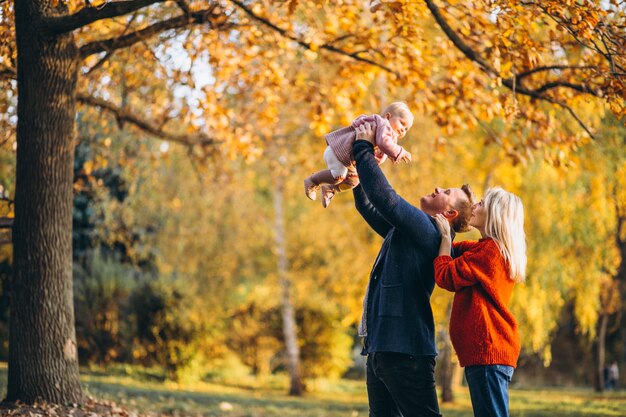 Familie met babydochter die in een de herfstpark loopt