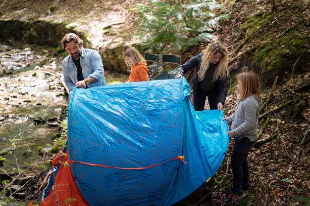 Familie met een hoge hoek die de tent opzet