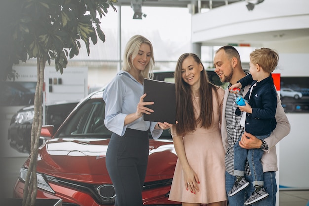 Familie met zoon die een auto in een autotoonzaal kiest