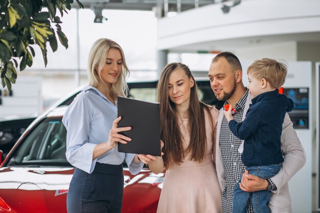 Familie met zoon die een auto in een autotoonzaal kiest