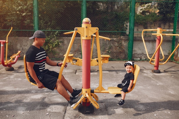 Gratis foto familie met zoontje spelen op een speelplaats