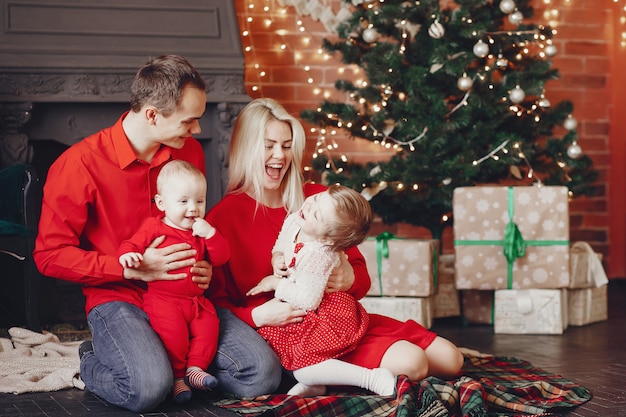 Familie om thuis te zitten in de buurt van de kerstboom