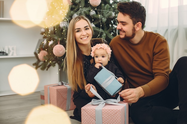 Familie om thuis te zitten in de buurt van de kerstboom