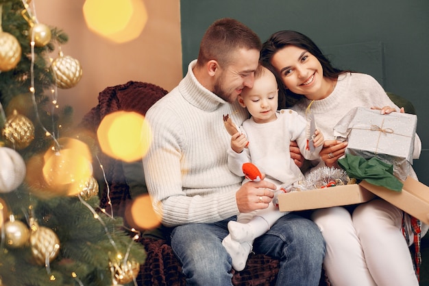 Familie om thuis te zitten in de buurt van de kerstboom