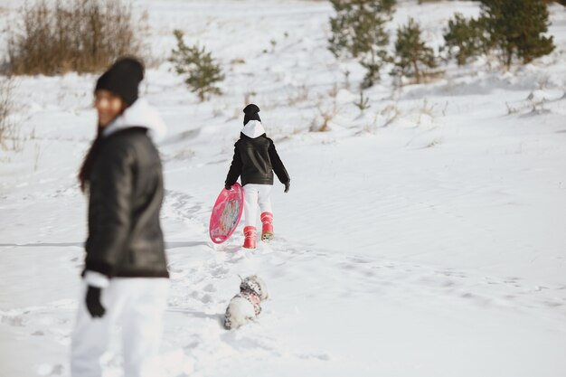 Familie op familie kerstvakantie. Vrouw en meisje in een bos. Mensen lopen.