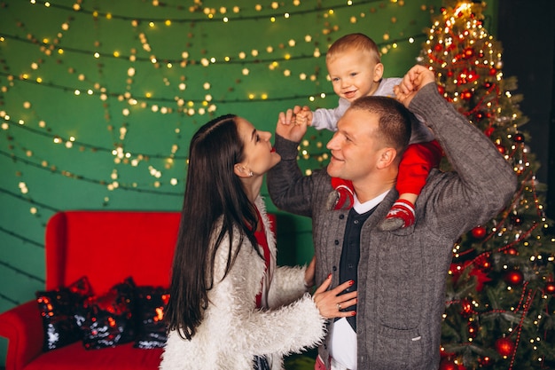 Gratis foto familie op kerstmis door de kerstboom