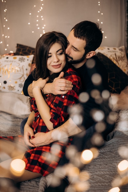 Familie portret. Charmant paar van zwangere vrouw in geruit overhemd en knappe man poseren in een gezellige