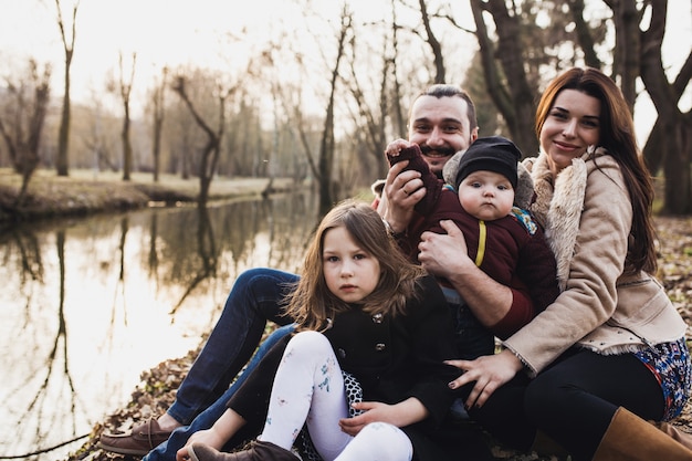 Familie poseren aan de oever van het meer