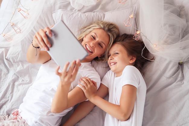 Familie scène. Gelukkige moeder en dochter in een bed