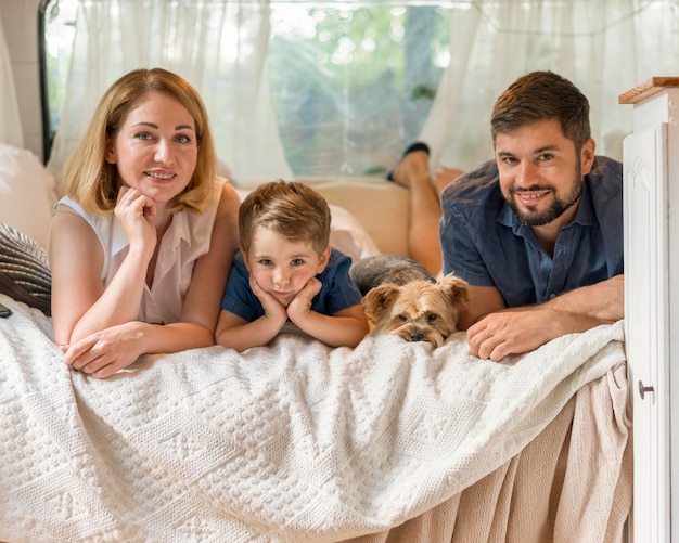 Familie tijd doorbrengen in bed in een caravan met hun hond