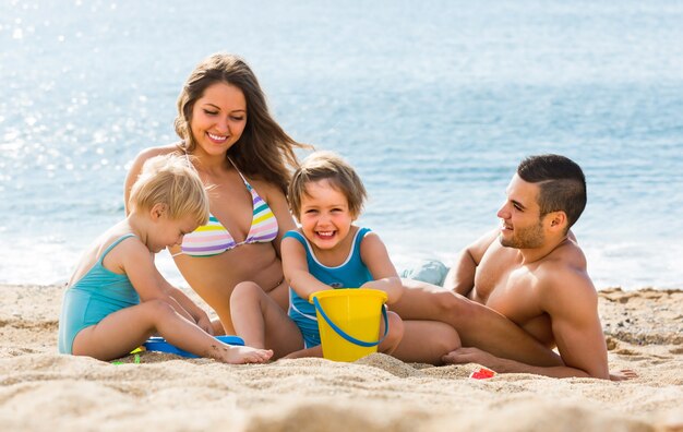 Familie van vier op het strand