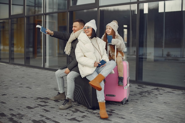 Familie zit buiten op een bagage en wacht op reizen