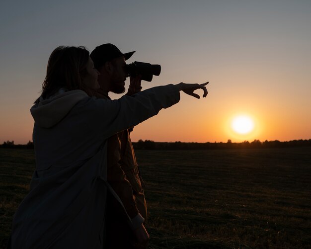 Familiesilhouet op middellange afstand met plezier bij zonsondergang