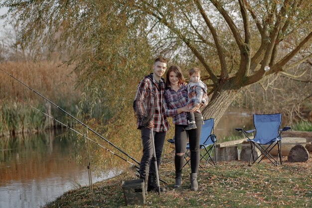 Familiezitting dichtbij rivier in een visserijochtend