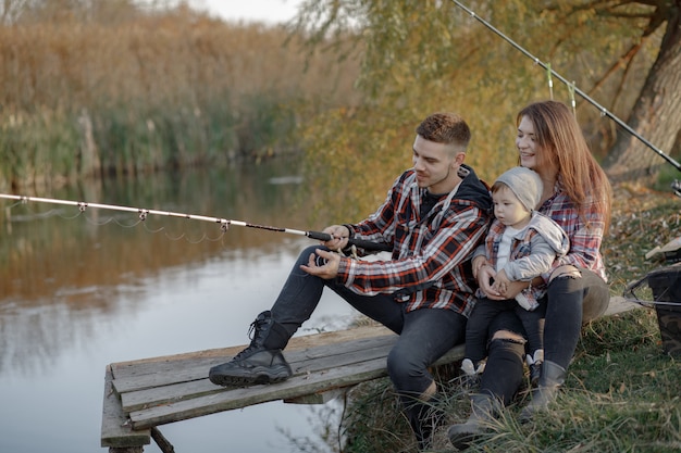 Familiezitting dichtbij rivier in een visserijochtend