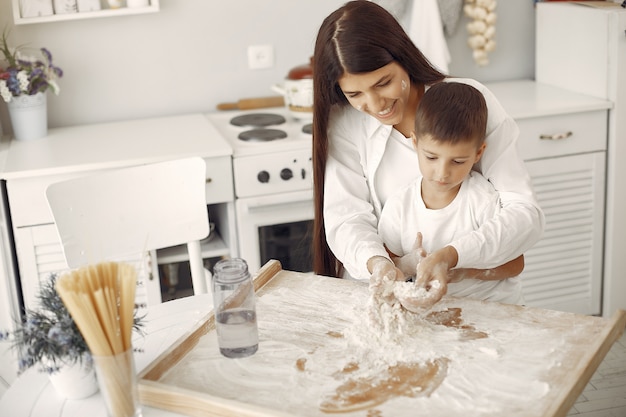 Familiezitting in een keuken en kook het deeg voor koekjes