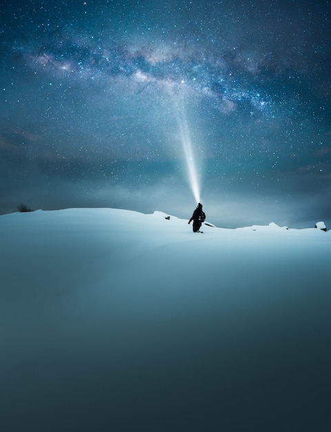 Fantasie concept van een reiziger schijnt en verlicht de prachtige sterrenhemel met de zaklamp