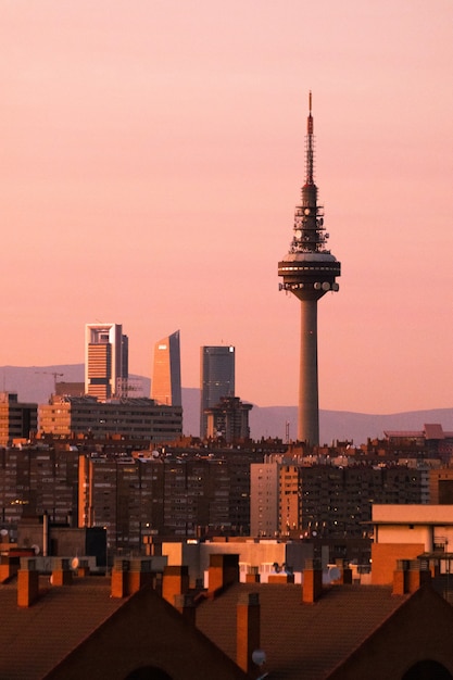 Gratis foto fantastisch stadsbeeld van madrid met zonovergoten moderne hoogbouw en tv-toren in de schemering