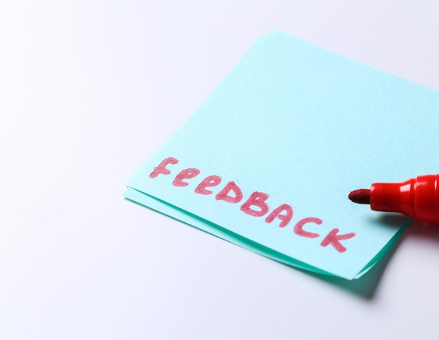 Feedback woord geschreven in een papieren notitie