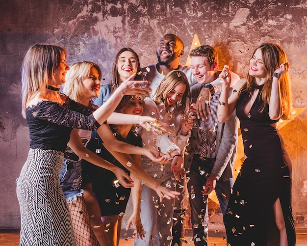 Feestelijke jonge vrienden met plezier met confetti