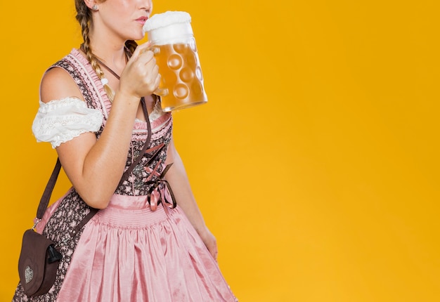 Feestelijke vrouw in kostuum klaar om bier te drinken