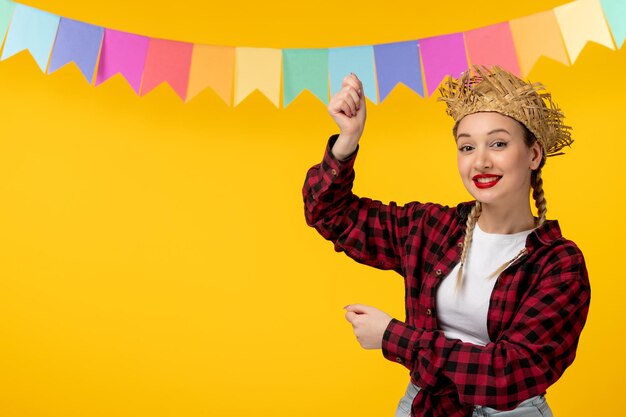 Festa junina blond schattig meisje in strohoed Braziliaans festival met kleurrijke vlaggen opgewonden