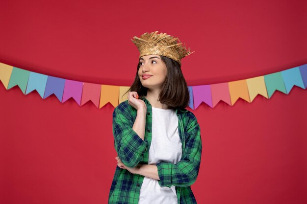 Festa junina gelukkig schattig meisje met een strohoed die het Braziliaanse festival viert en ver weg kijkt