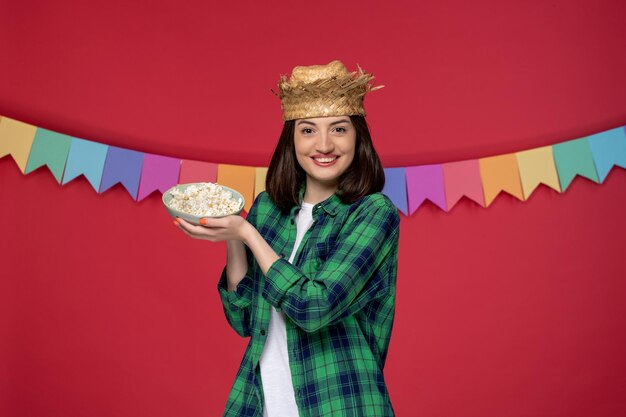 Festa junina in strohoed brunette schattig meisje viert braziliaans festival met popcorn