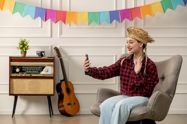 Festa junina schattig meisje in strohoed Braziliaanse midzomer met retro radiogitaar die selfie neemt