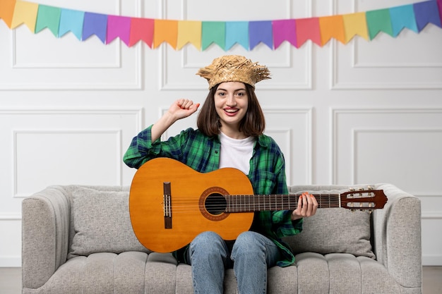 Festa junina schattig mooi meisje in groen shirt strohoed met kleurrijke vlaggen erg opgewonden