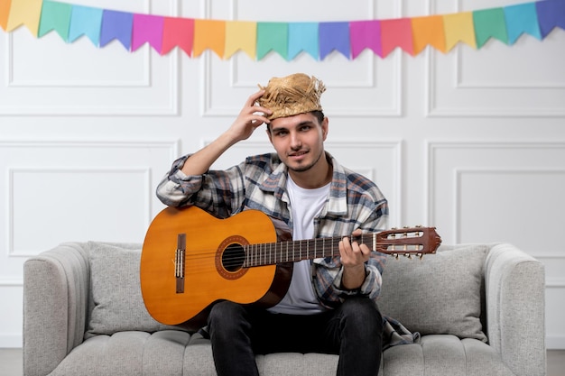 Festa junina schattige lieve kerel in geruit hemd in strohoed die het festival op gitaar viert