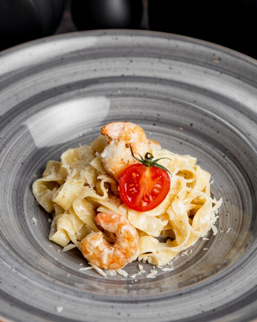 fettuccine pasta met garnalen, tomaten en geraspte kaas