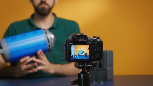 Filmmaker die mening over videolicht opneemt en haar voor de camera houdt. Professionele studiovideo- en fotoapparatuurtechnologie voor werk, fotostudio social media ster en influencer