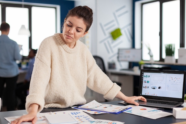 Financiële grafieken geanalyseerd in startend bedrijf door bedrijfseigenaar die aan het bureau staat. Succesvolle zakelijke professionele ondernemer online internetstatistieken, uitvoerend ondernemer, manager leider stan