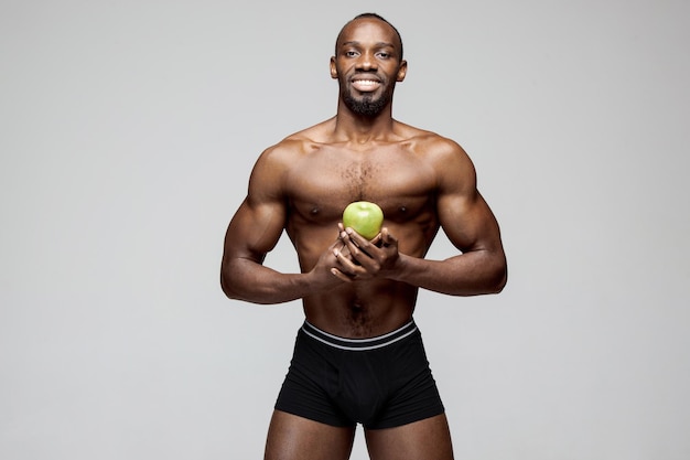 Fit jonge man met mooie torso geïsoleerd op een witte muur