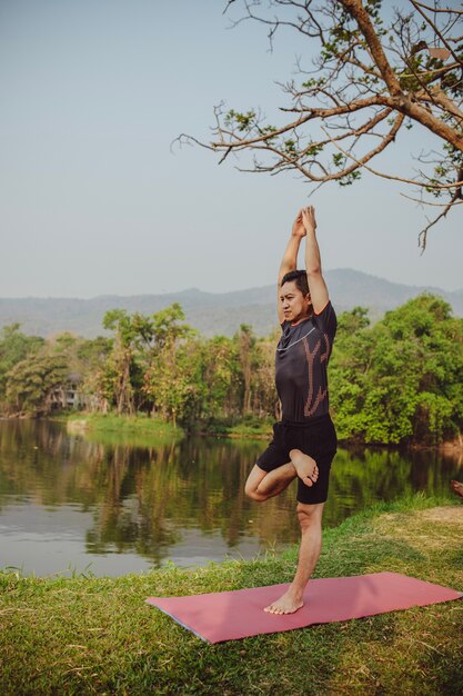 Fit man met yoga pose in de natuur