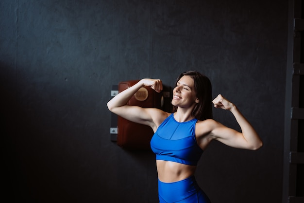 Fit vrouw die zich voordeed op de camera. Persoonlijke trainer die haar vorm toont. Schoonheid van moderne sport.