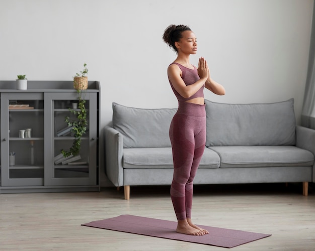 Fitness vrouw doet yoga op een yogamat thuis